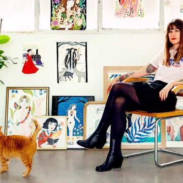 María Hesse posa junto a algunas de sus ilustraciones y una de sus gatas